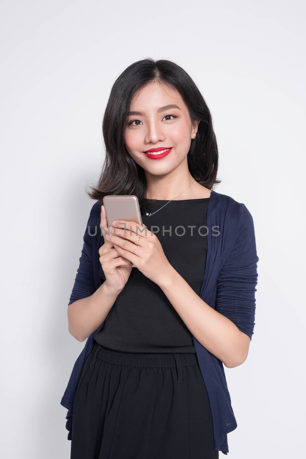 Young asian woman using smartphone isolated on white. by makidotvn