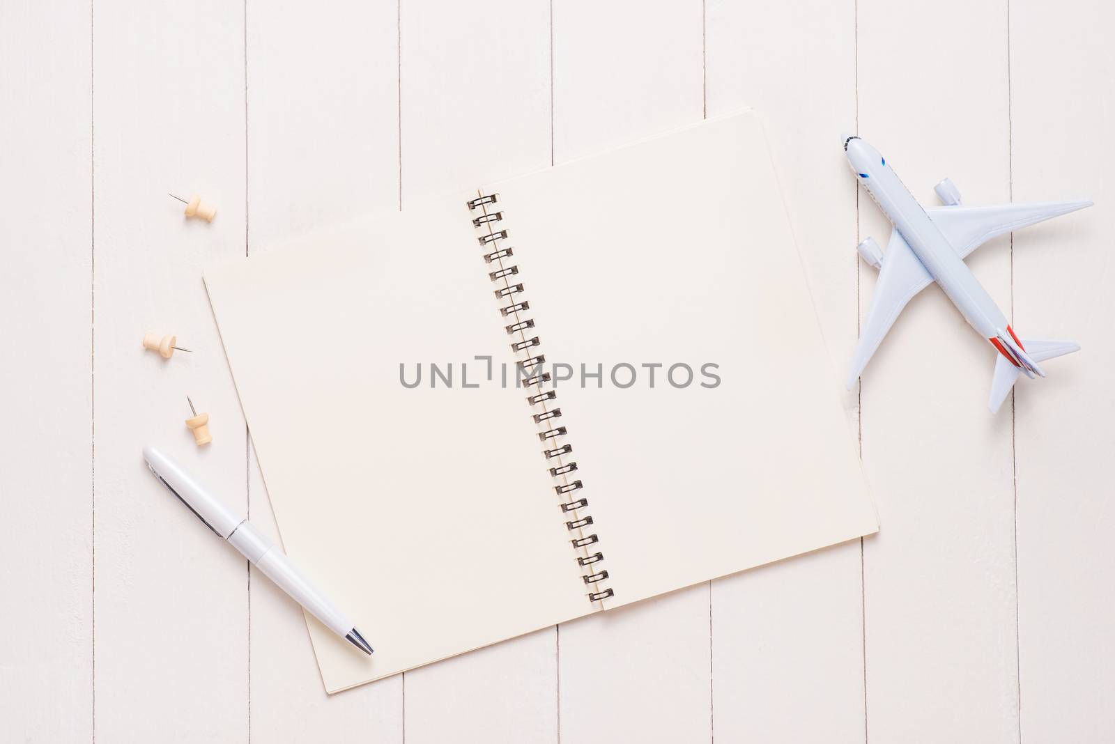 Business trip concept. Airplane and blank open notebook for your by makidotvn