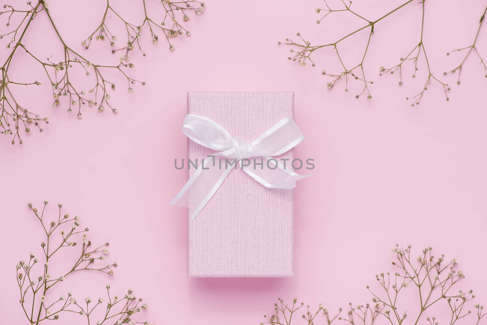 Gift box tied with pink ribbon and white flowers for mothers day by makidotvn