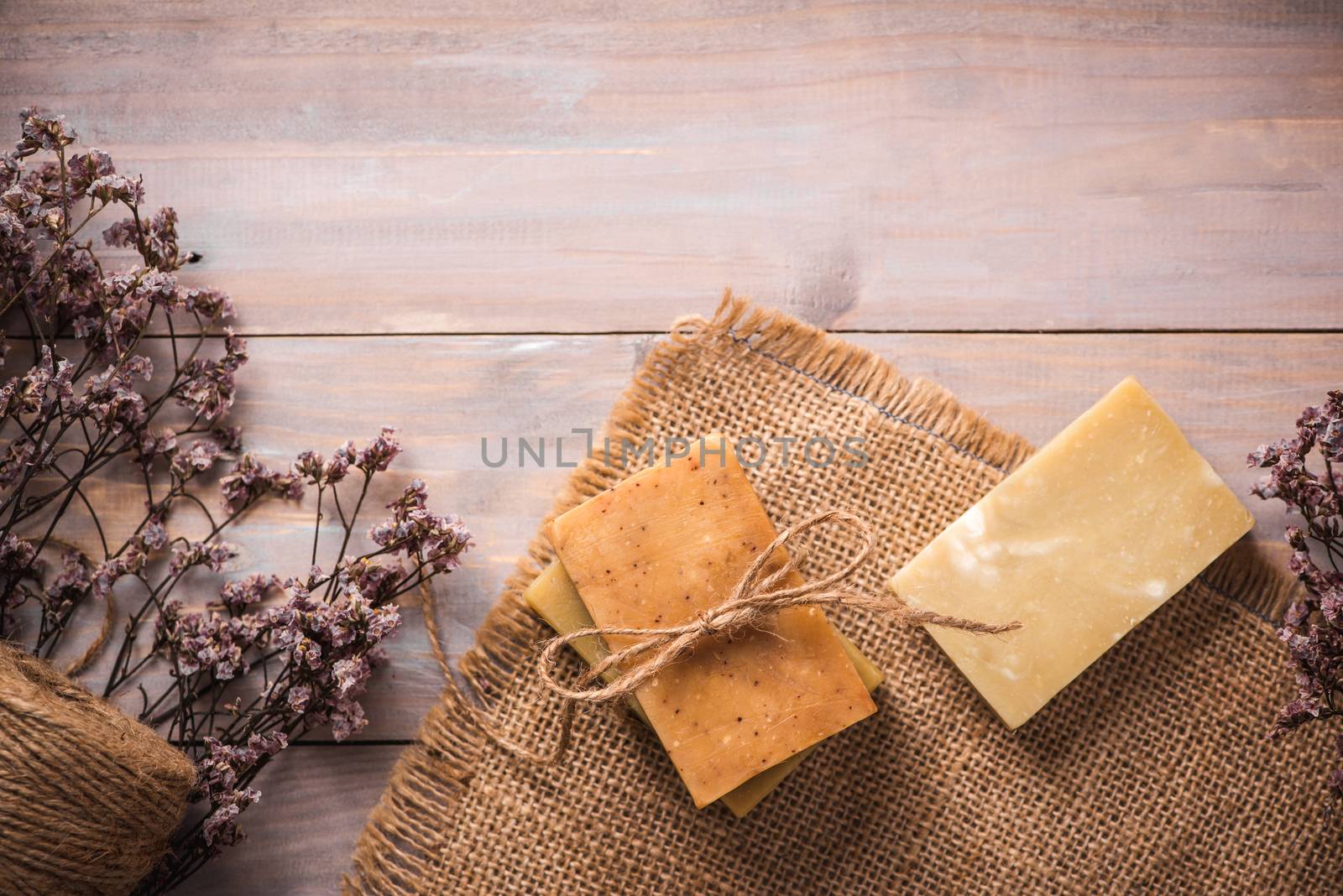 Natural soap with dried flowers on wooden background. by makidotvn
