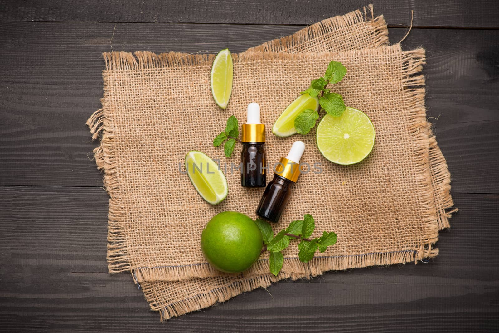 Natural cosmetics for home spa. Bottle of essence oil with fresh limes 