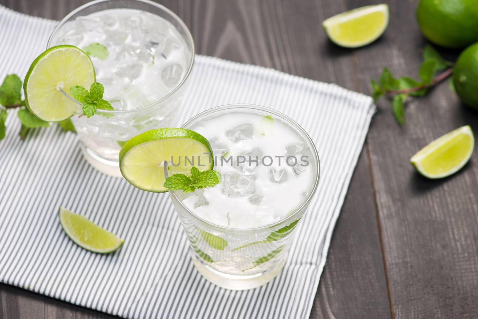 Fresh cocktail with lime, ice and mint on a rustic background. C by makidotvn