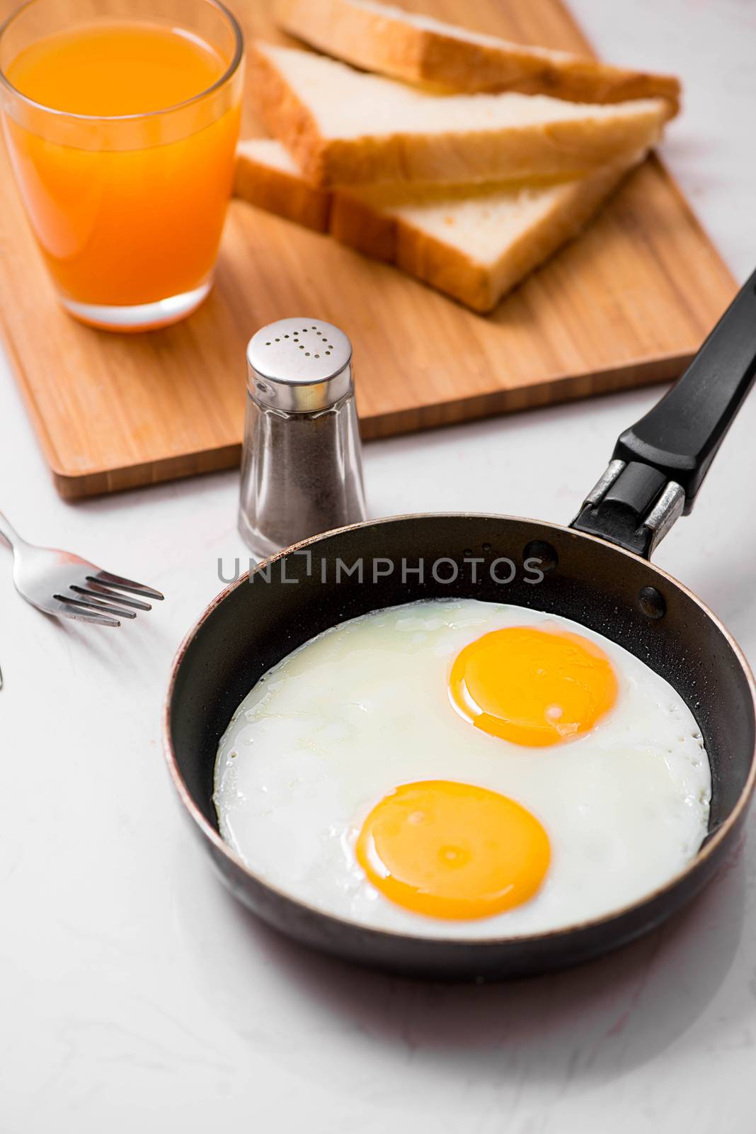 Top view of traditional healthy easy quick breakfast meal made of fried eggs served on a frying pan.