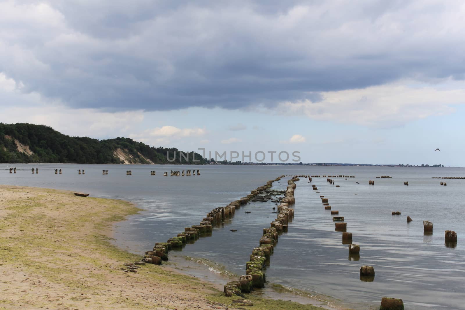 Breakwaters on the beach. Cloudy wheather and very cold day.