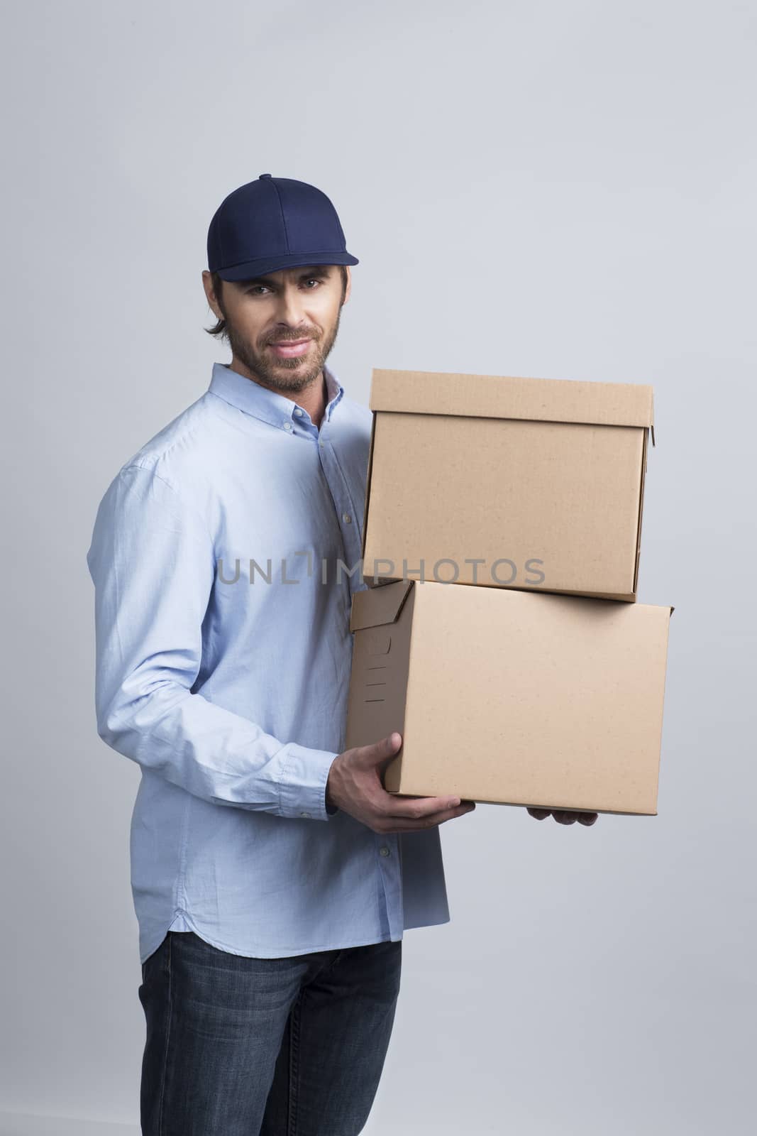 Studio shot of African delivery man carrying boxes