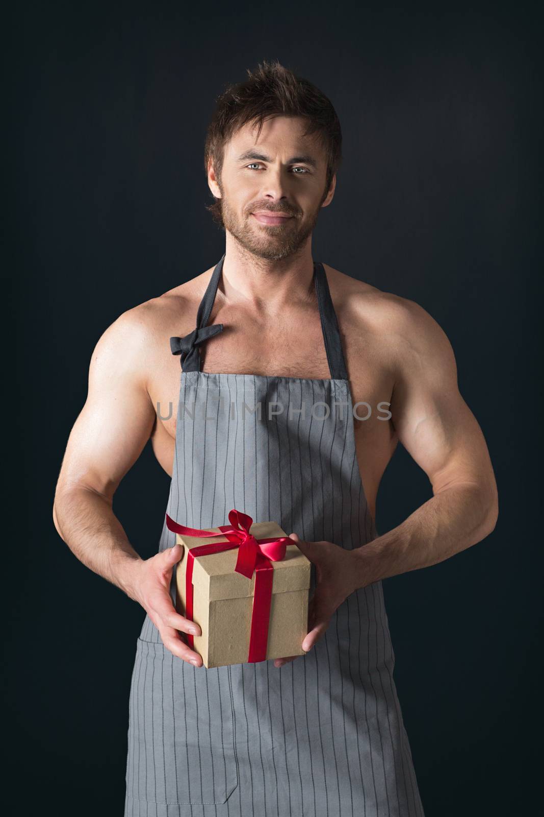 Muscular man in apron holding gift by ALotOfPeople