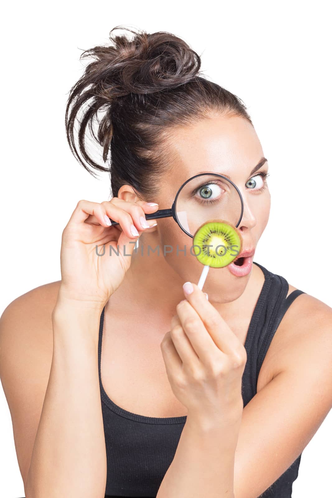 Woman looking at kiwi slice through magnifying lens, isolated on white background