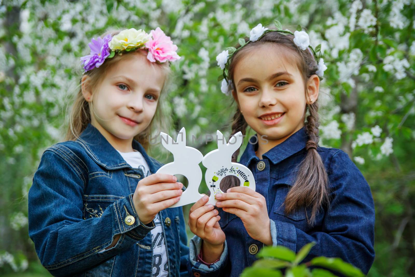 Two girls with toy bunnies at spring