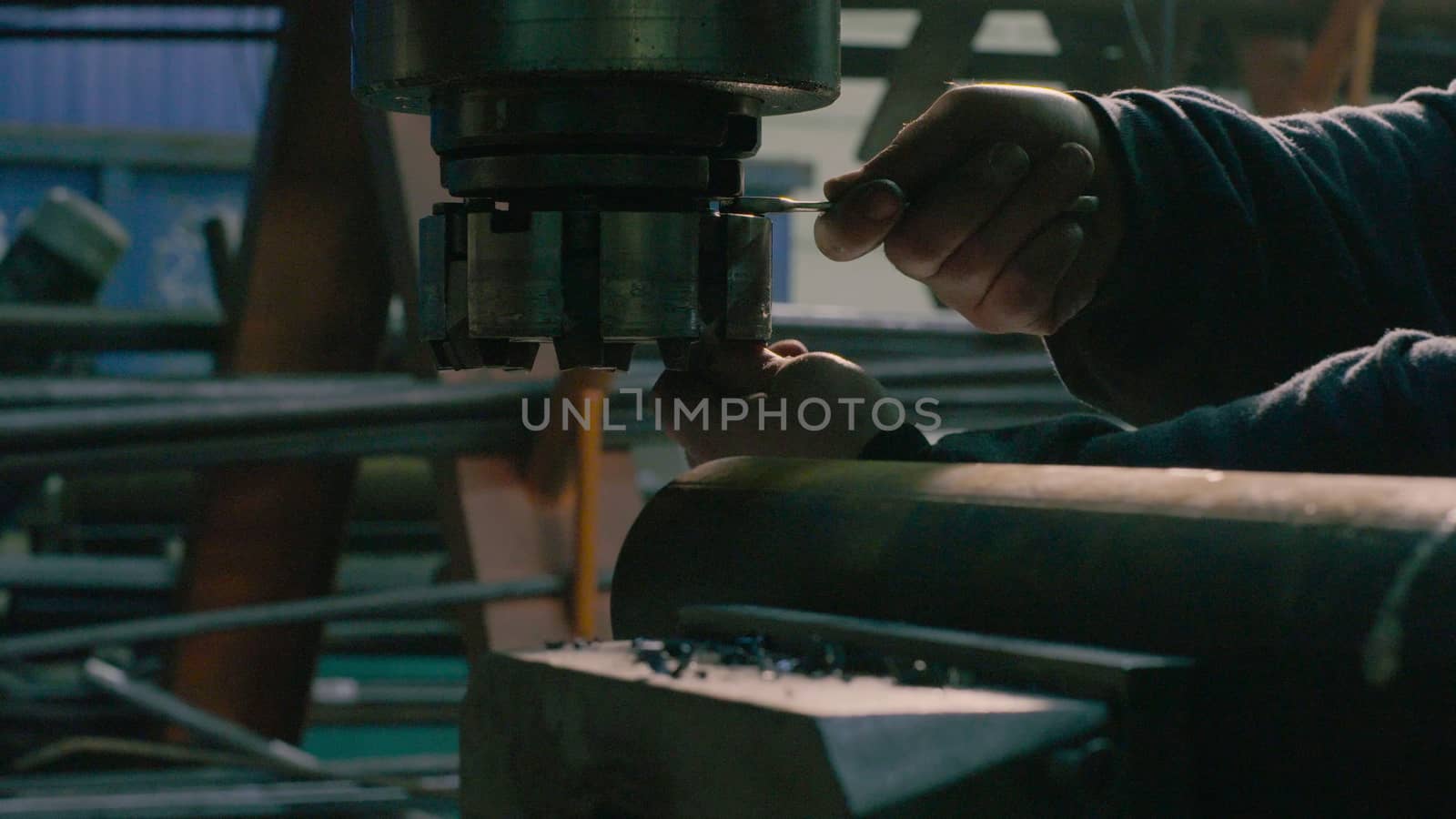 Close up of men's hands screwing the milling cutter on the milling machine