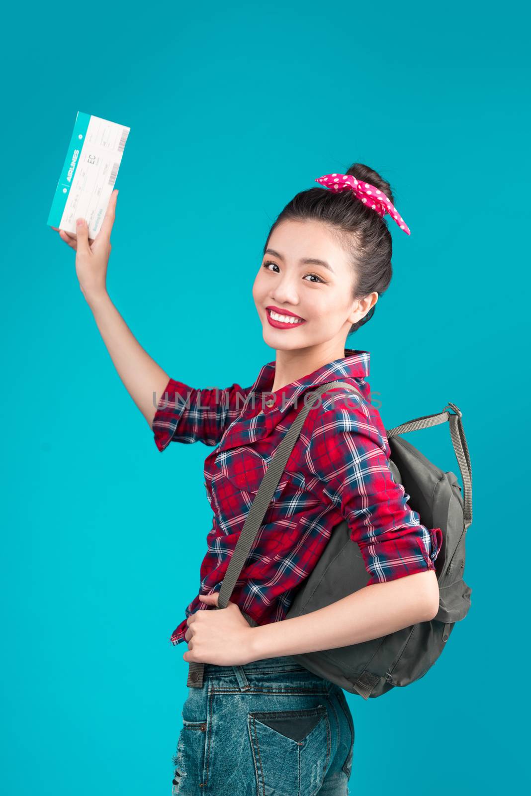 Woman travel. Young beautiful asian woman traveler with air ticket on blue background