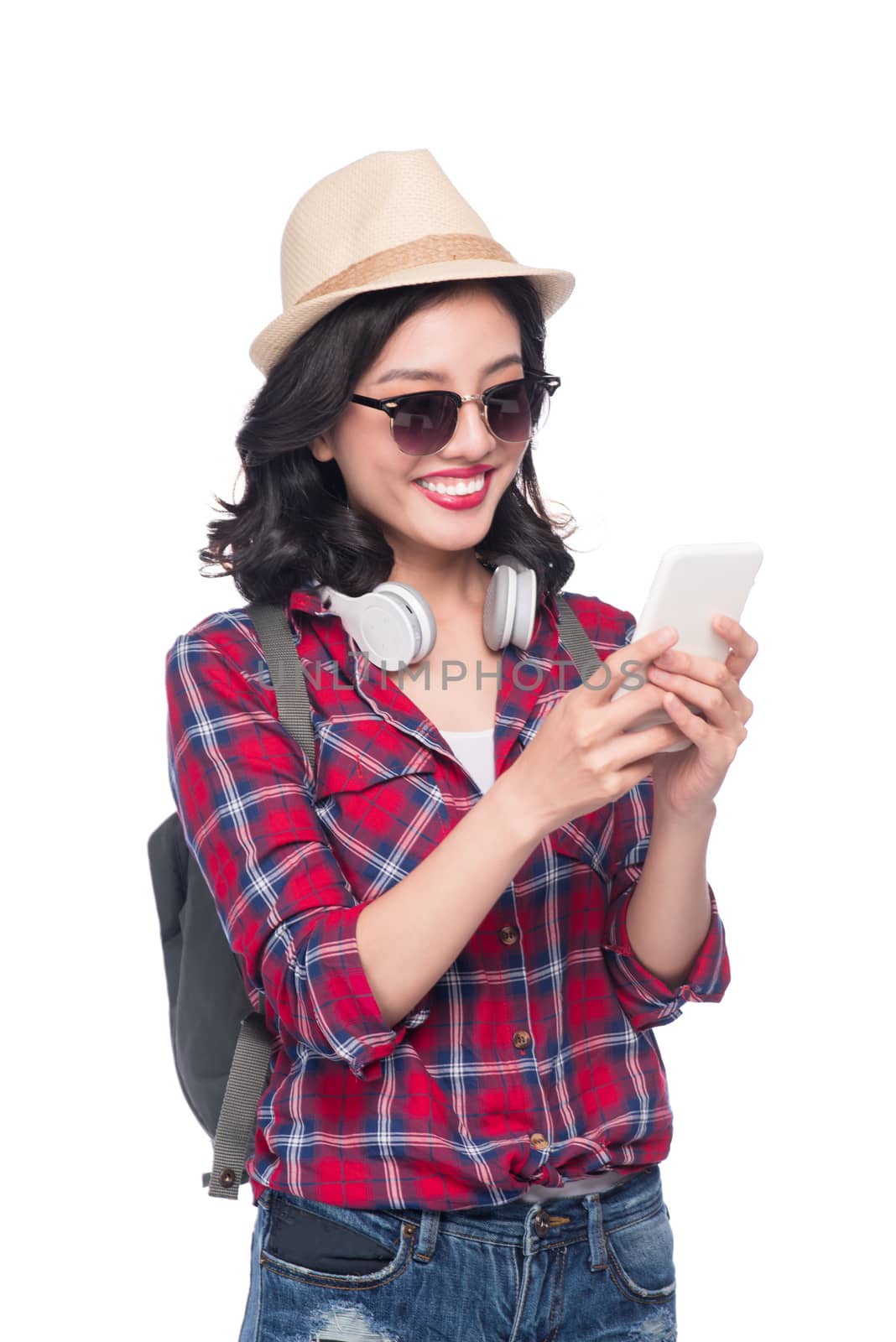 Happy young asian woman using smartphone standing isolated on white.