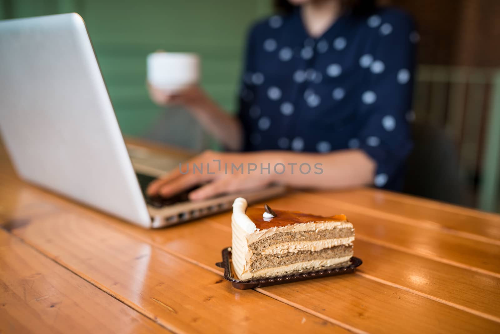 Beautiful cute asian young businesswoman in the cafe, using laptop and drinking coffee