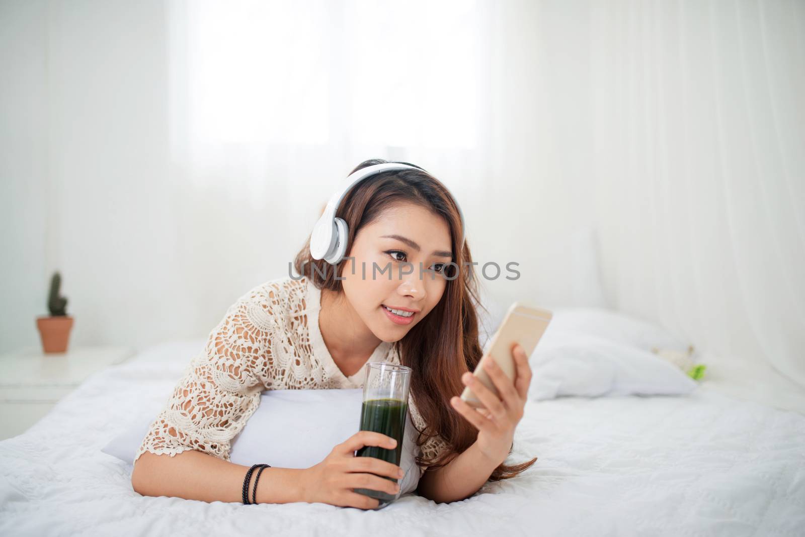Woman Relaxing in bed and using mobile phone, relaxing in her living room