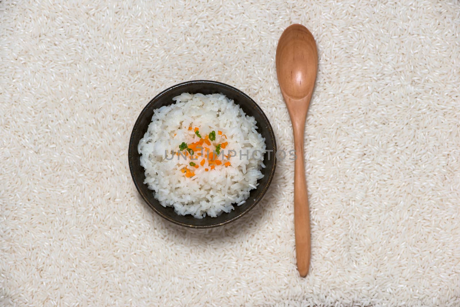 Boiled rice in a bowl on wooden table.