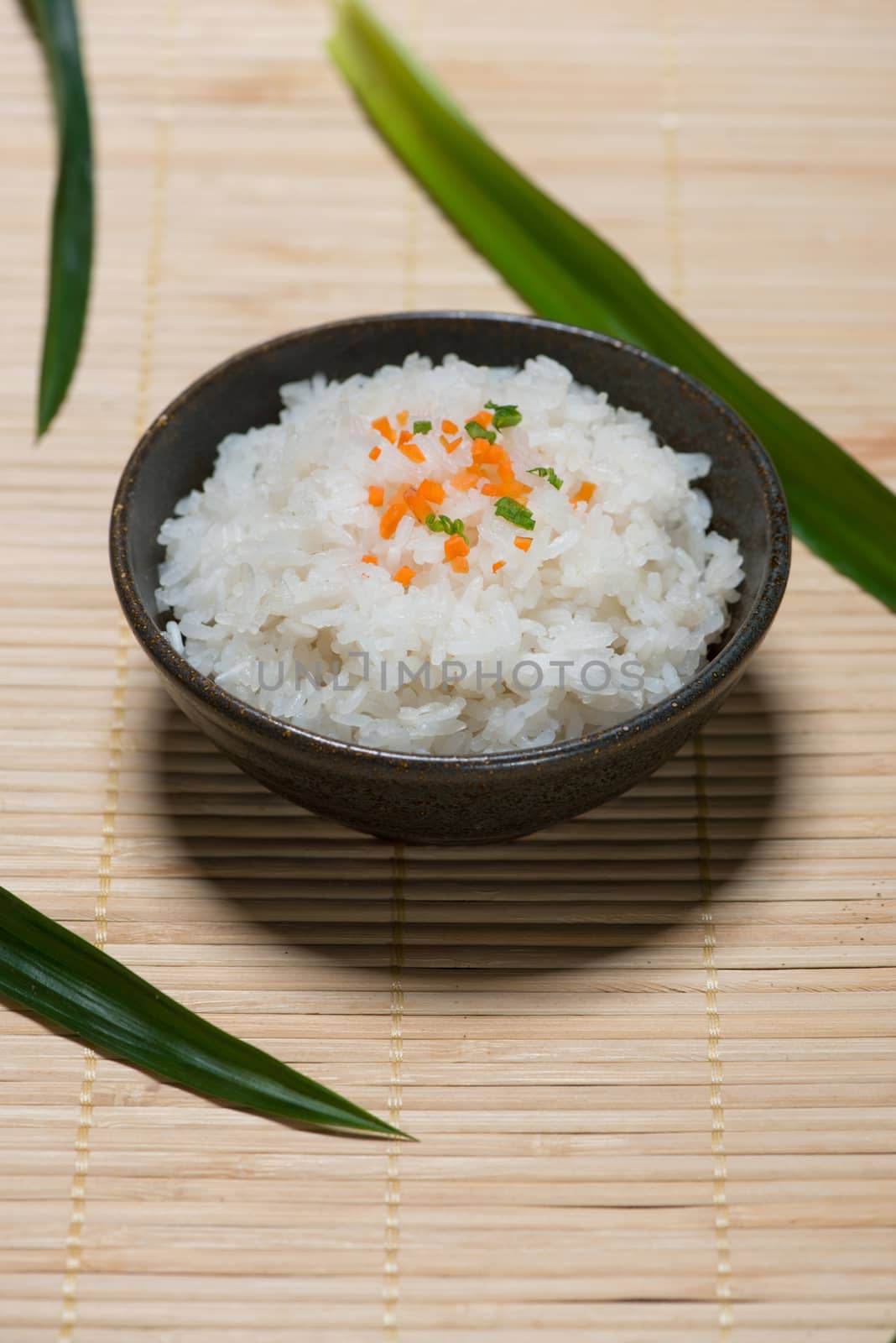 Boiled rice in a bowl on wooden table.