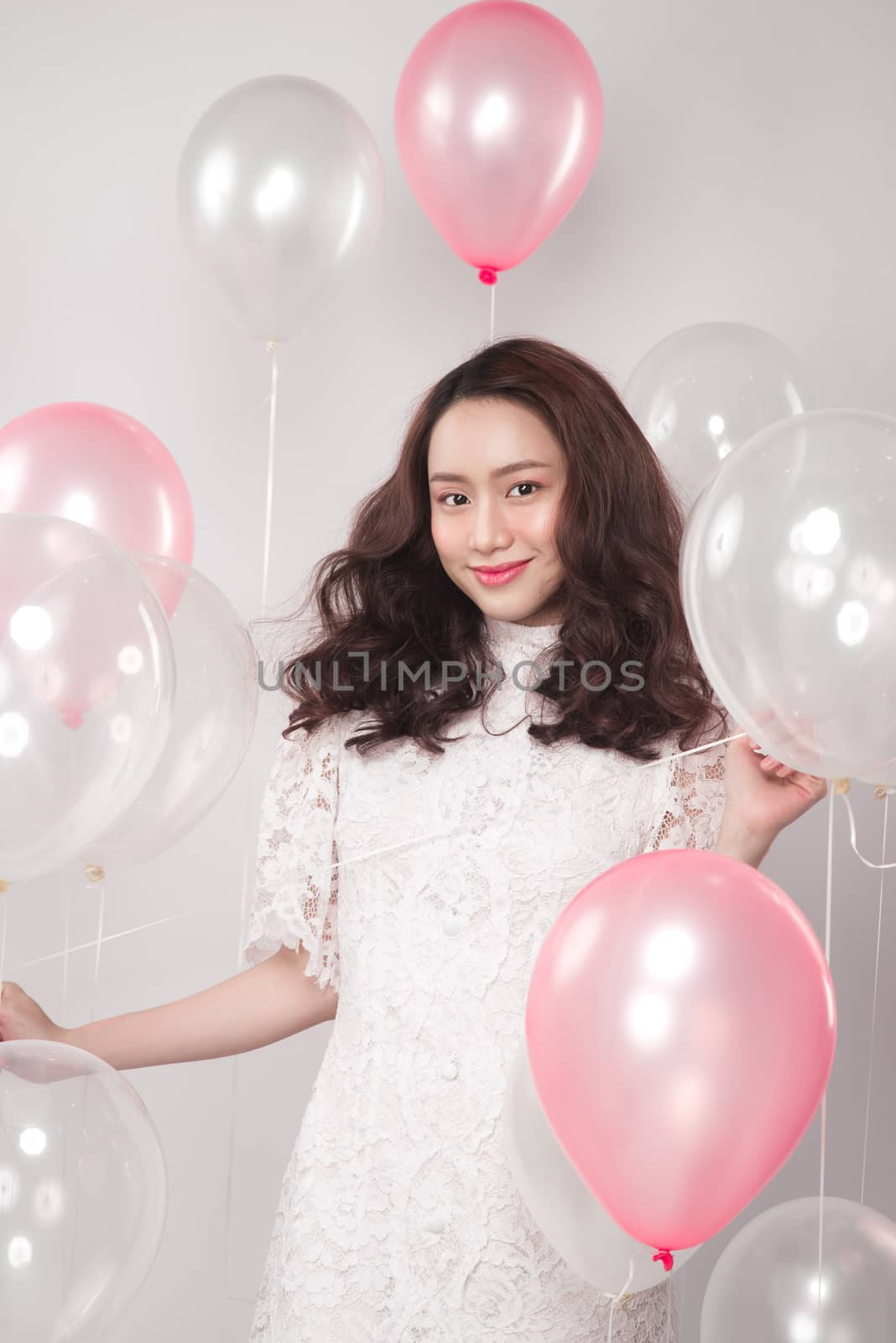 Asian pretty fashionable woman in white dress with pastel balloons