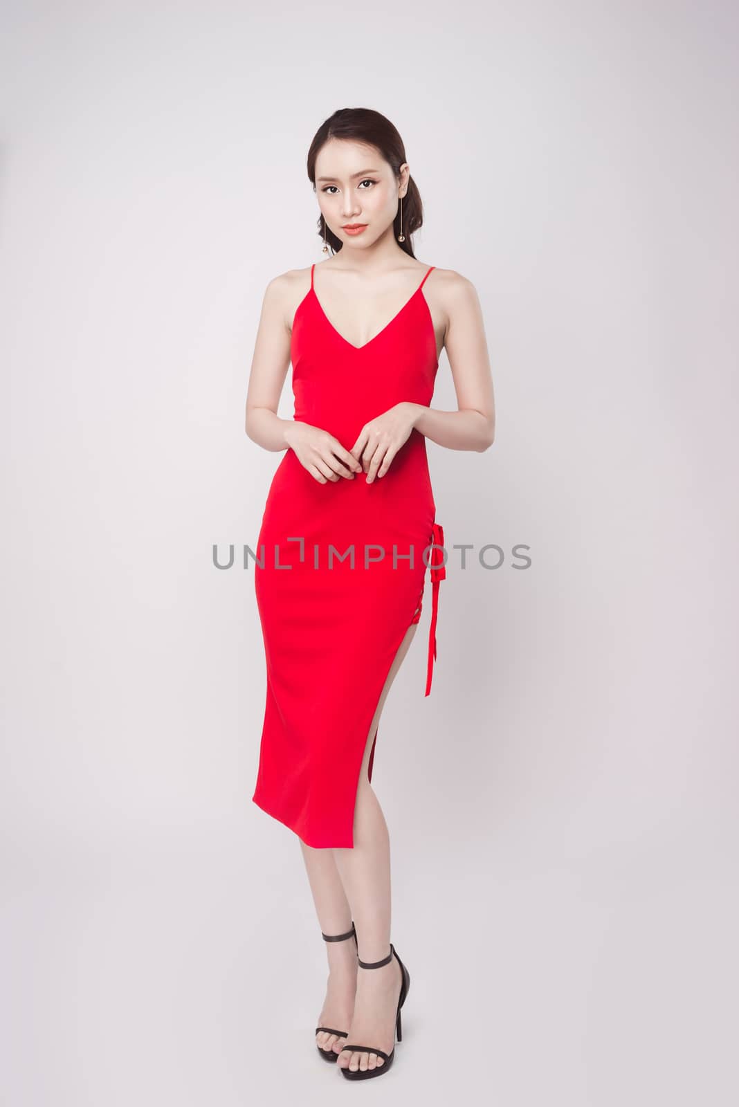 Beautiful stylish asian woman wearing red dress on grey backgrou by makidotvn