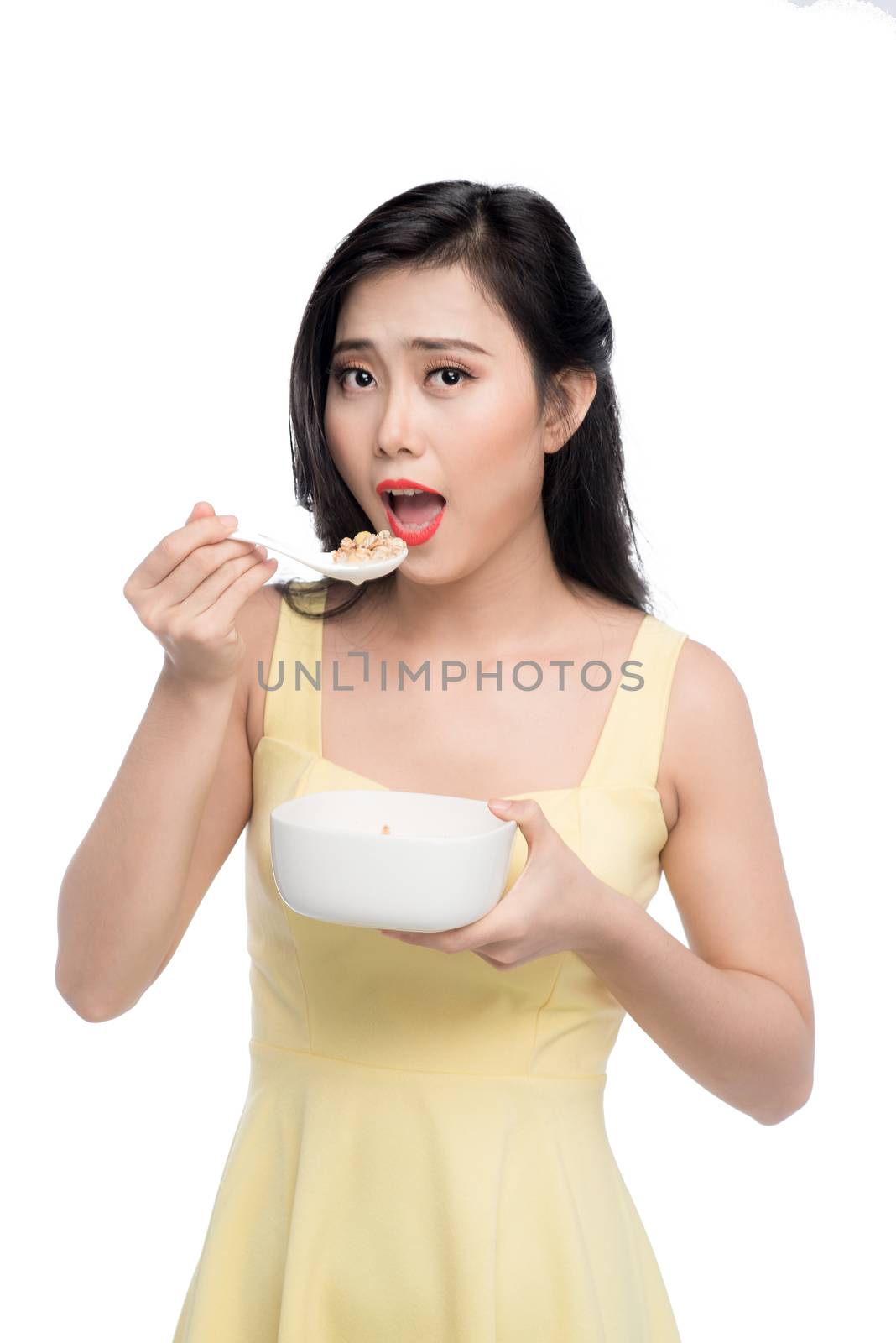 Asian woman eating bowl of cereal or muesli for breakfast