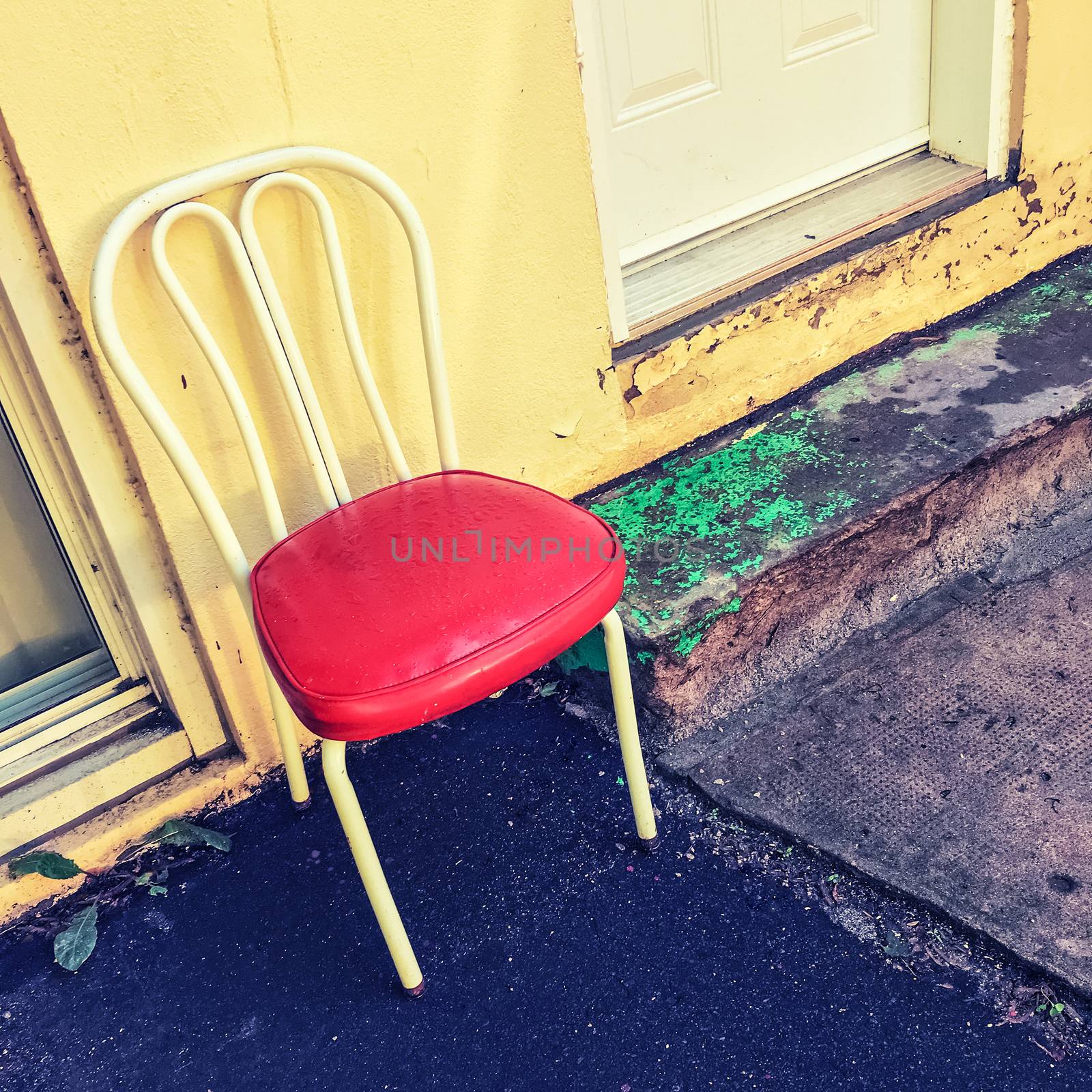 Bright chair outside the house. Old building exterior.