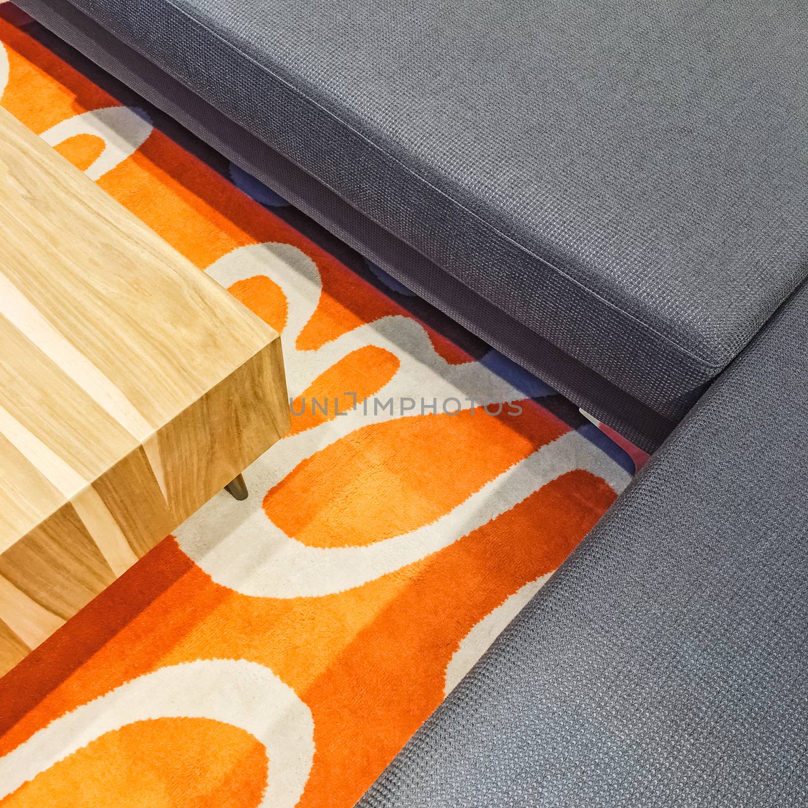 Gray corner sofa, coffee table and orange carpet. Modern furniture.