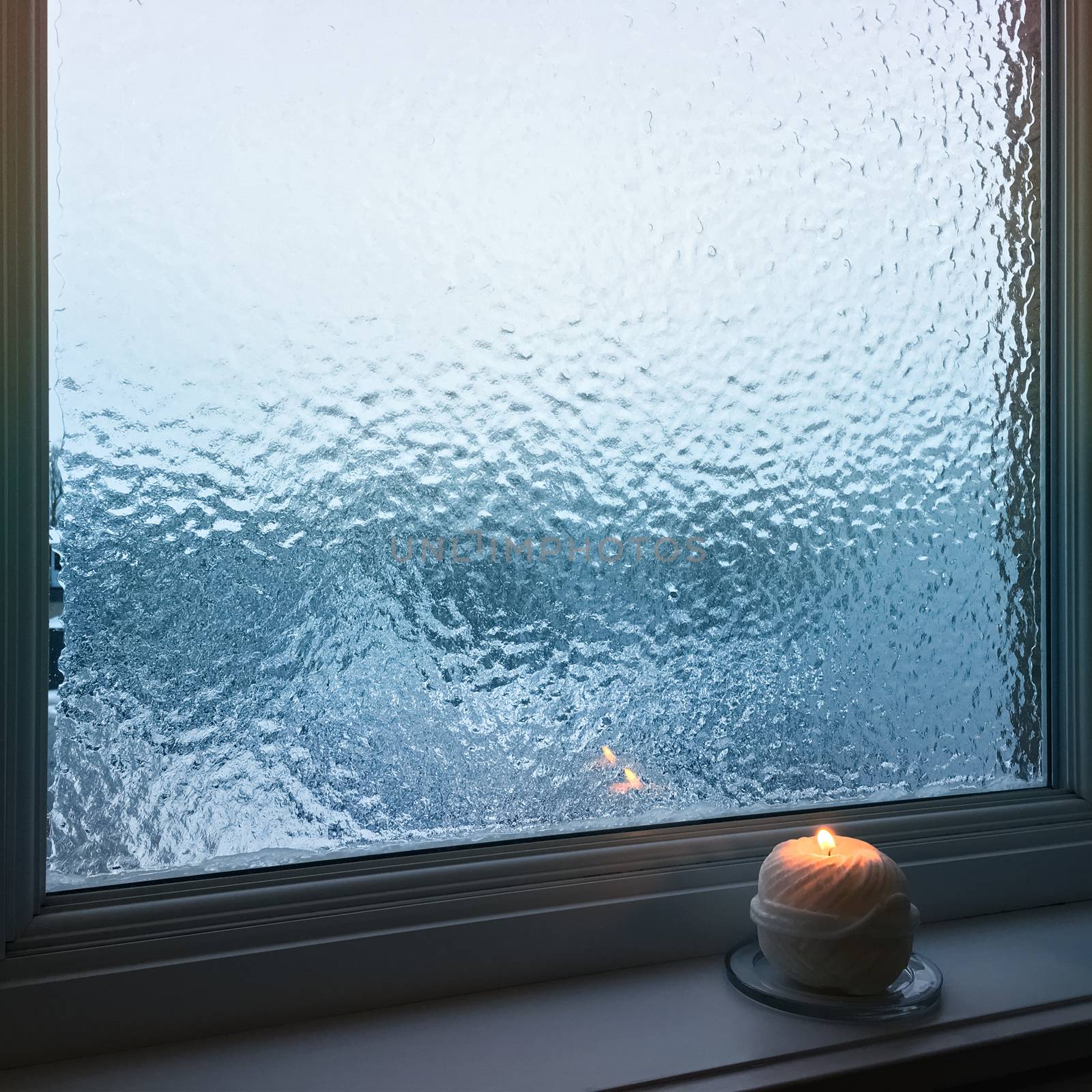 Blue frosted window and cozy candlelight by anikasalsera