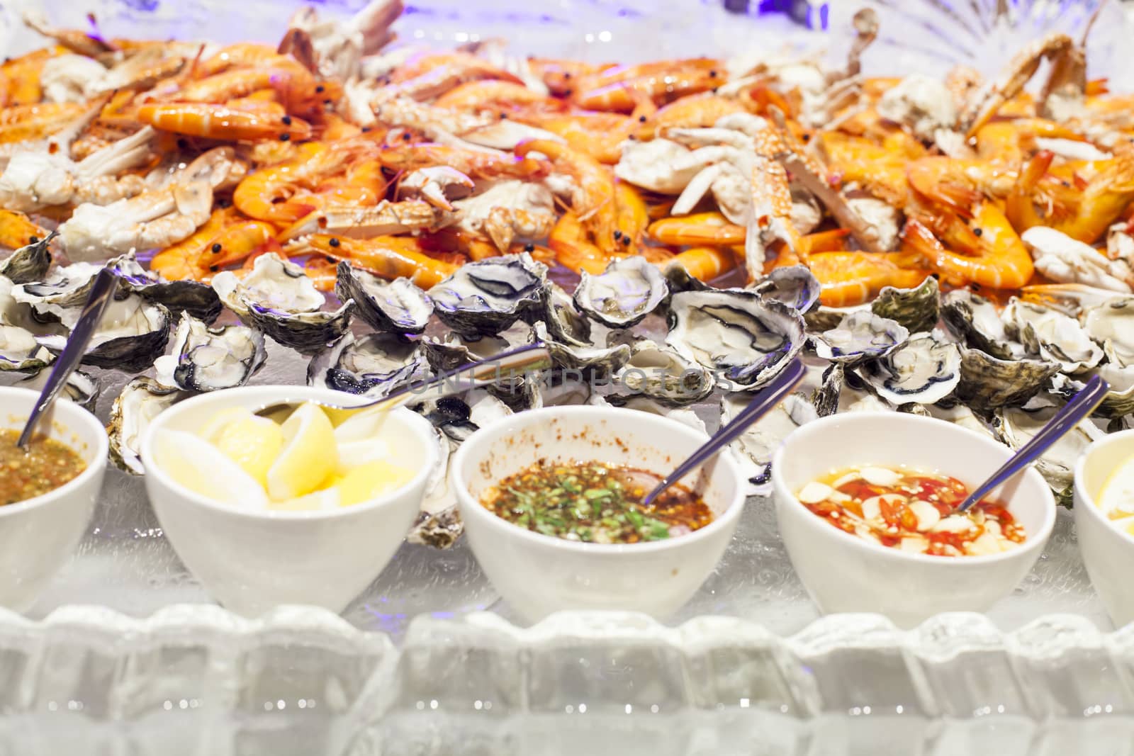 Seafood buffet on ice in a restaurant, with fresh shrimp squid clams crabs and lobster.