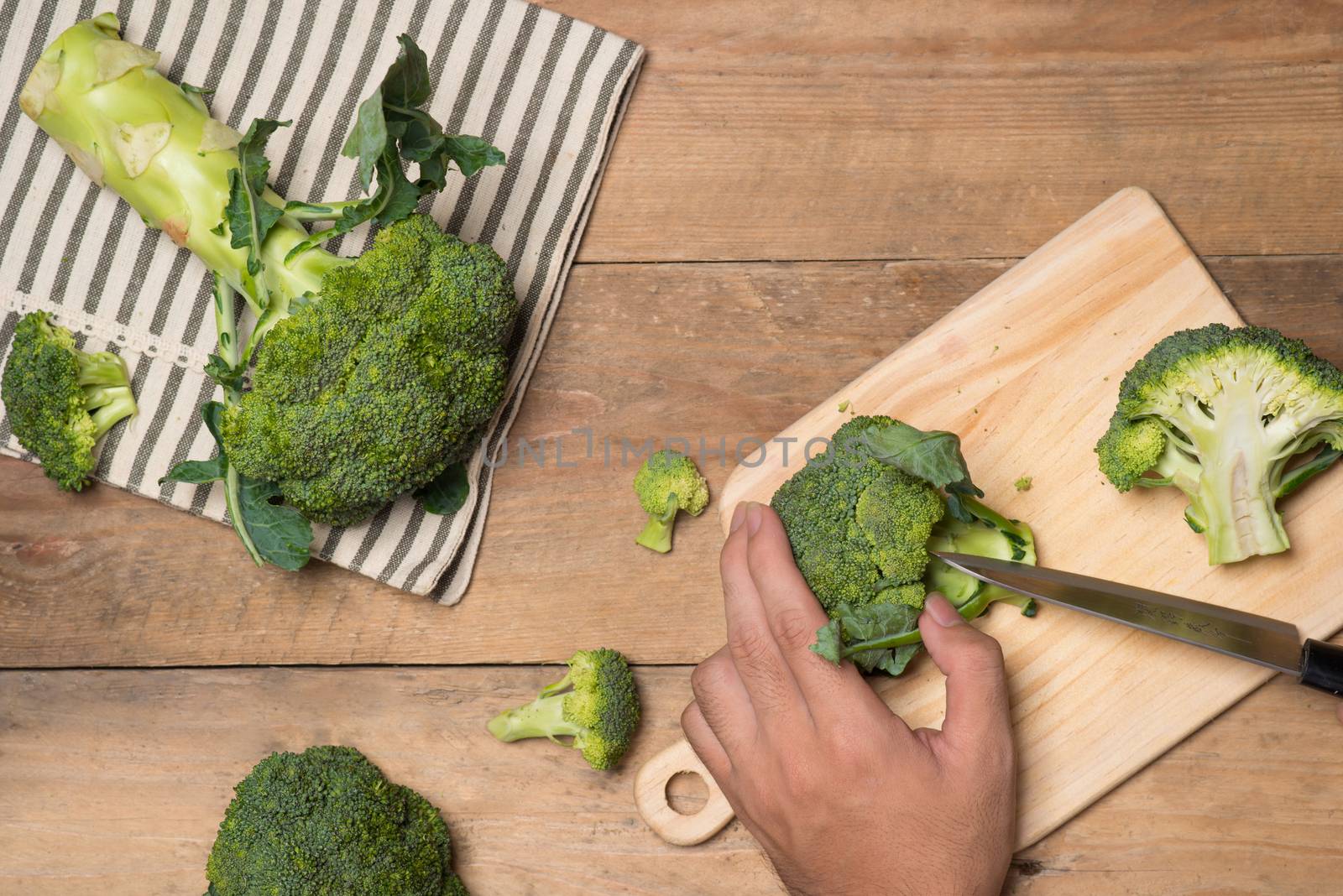 Top view of Chef hand cutting broccoli for cooking