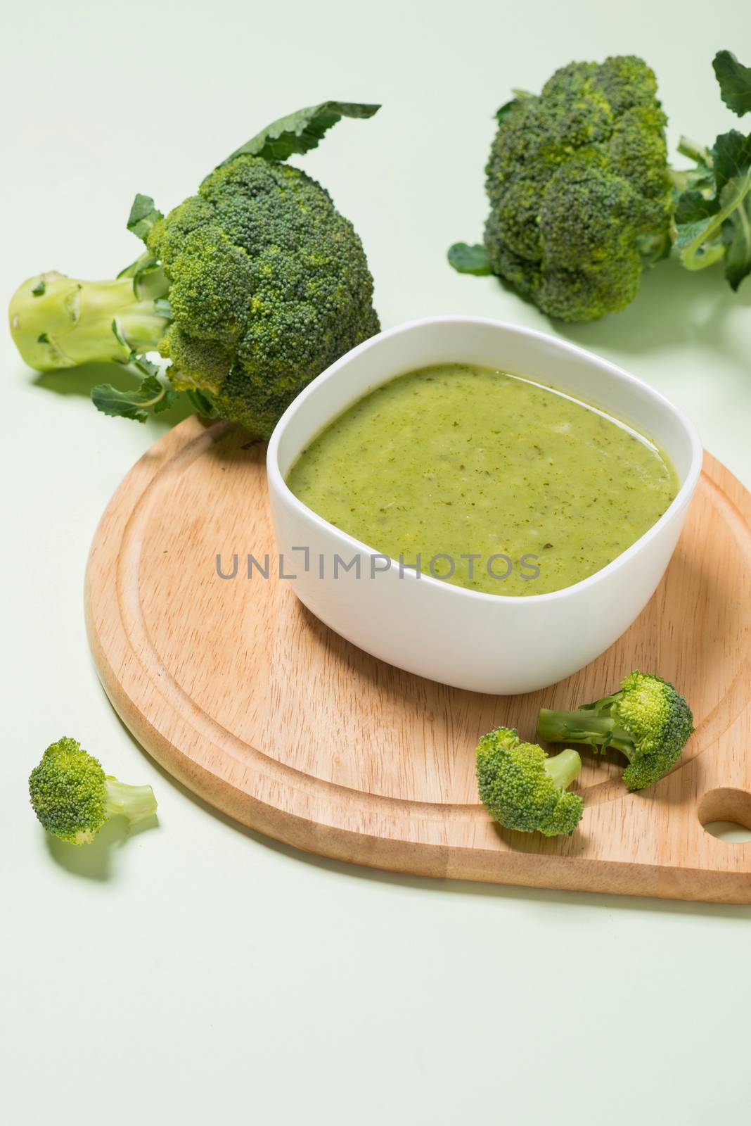 Tasty broccoli soup on a green background