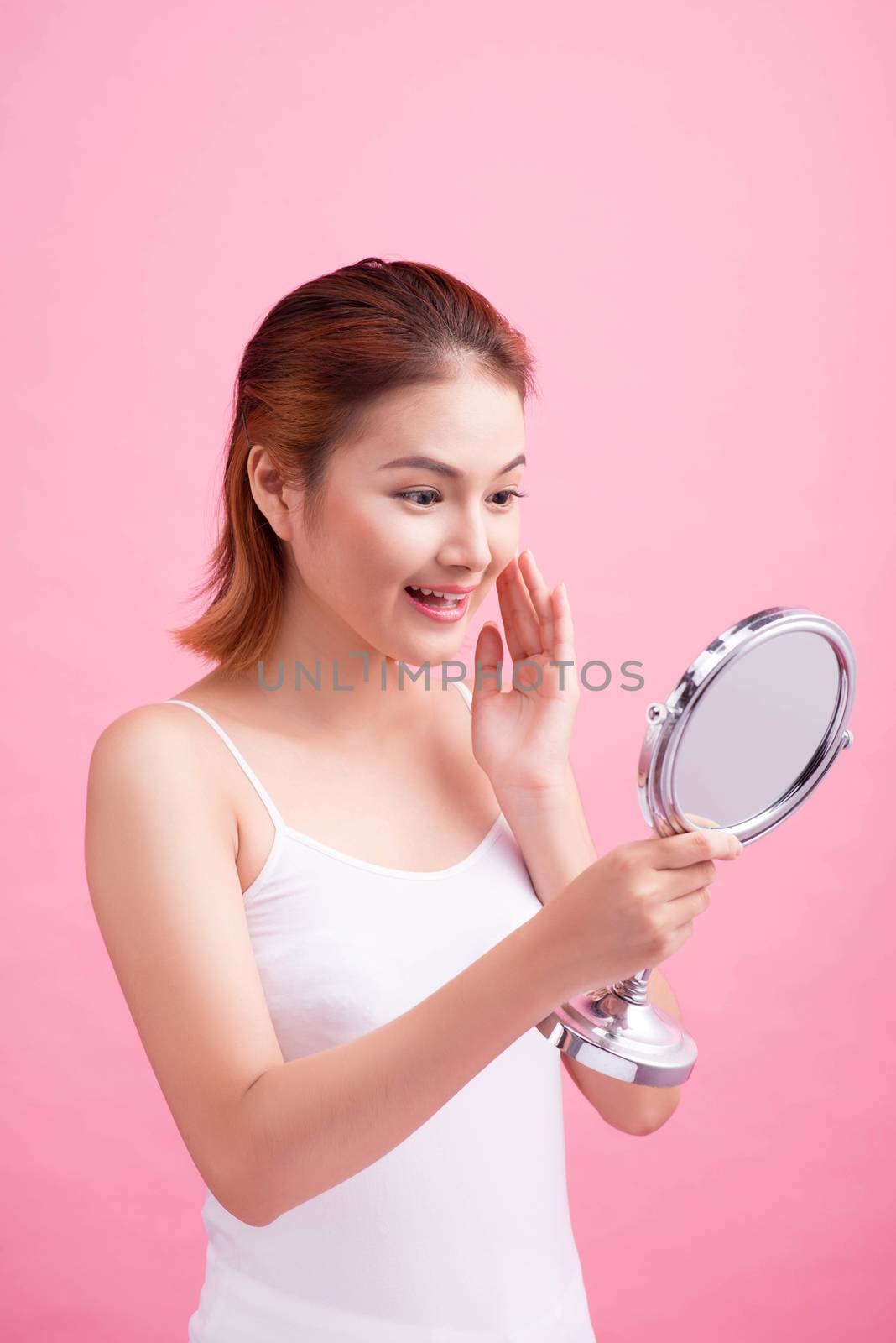 Face of young beautiful healthy asian woman and reflection in the mirror