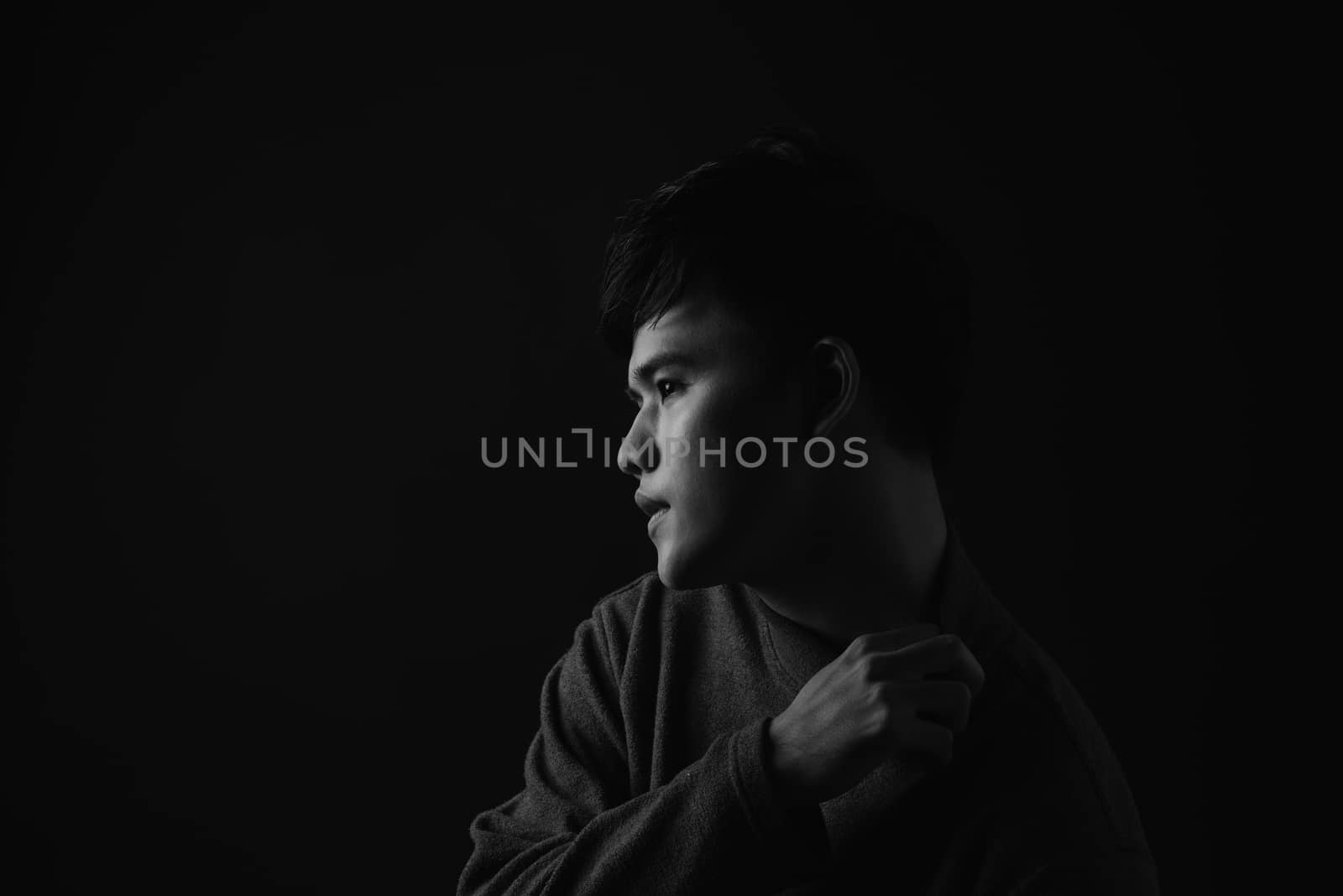 Young asian man's portrait against black background