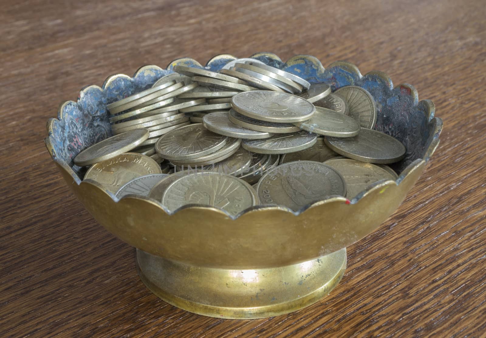 Bras cup filled with coins
