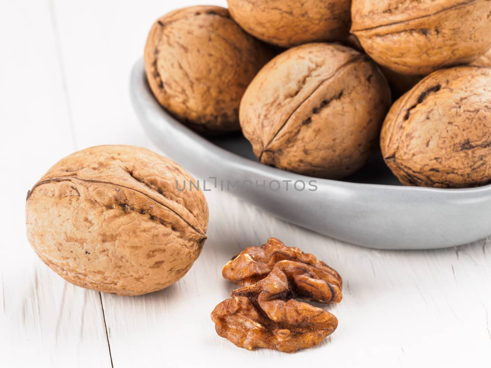 Close up view on inshell walnut on white wooden background