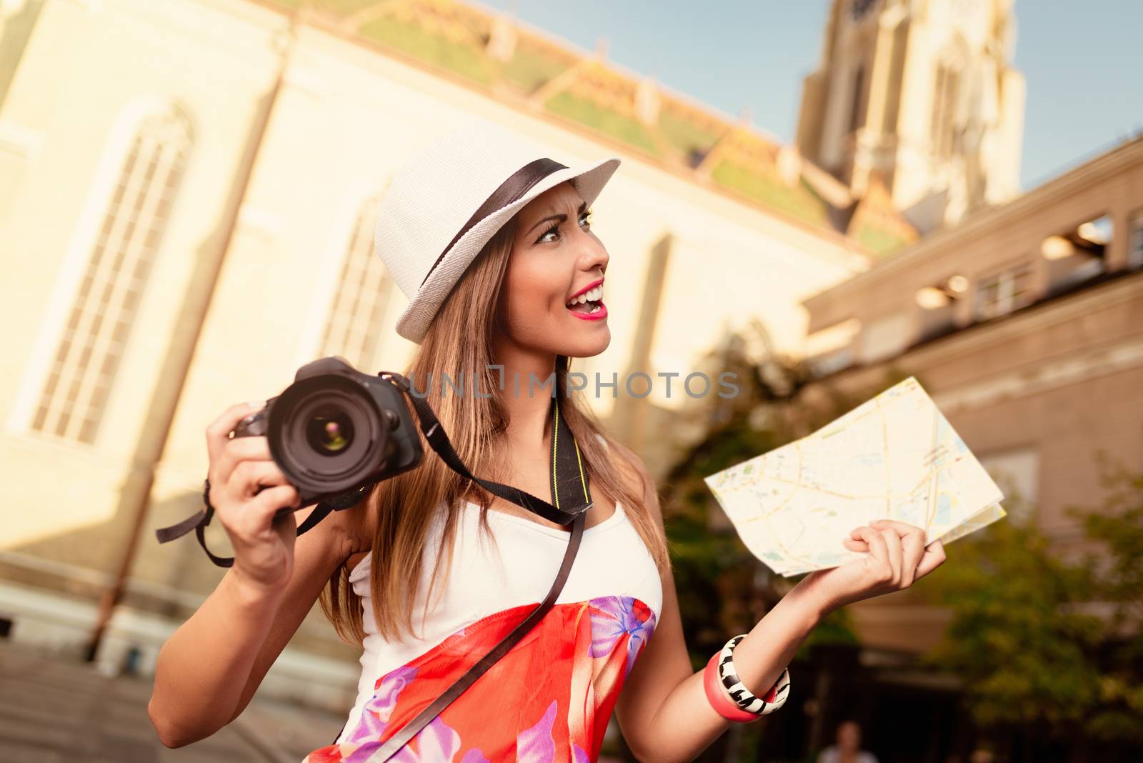 Beautiful young worried woman on vacation walking on the city and holding map of city and digital camera.