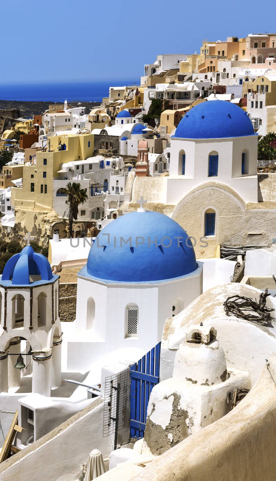 Oia town on Santorini island, Greece. Traditional and famous houses and churches with blue domes over the Caldera, Aegean sea