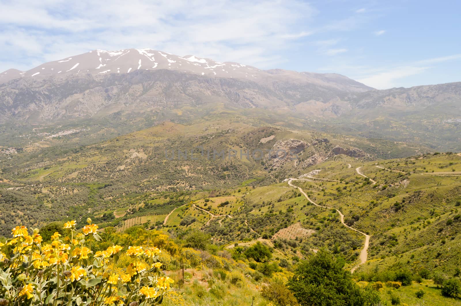 Winding road in the mountain of the center of Crete with the snowy ida mountain