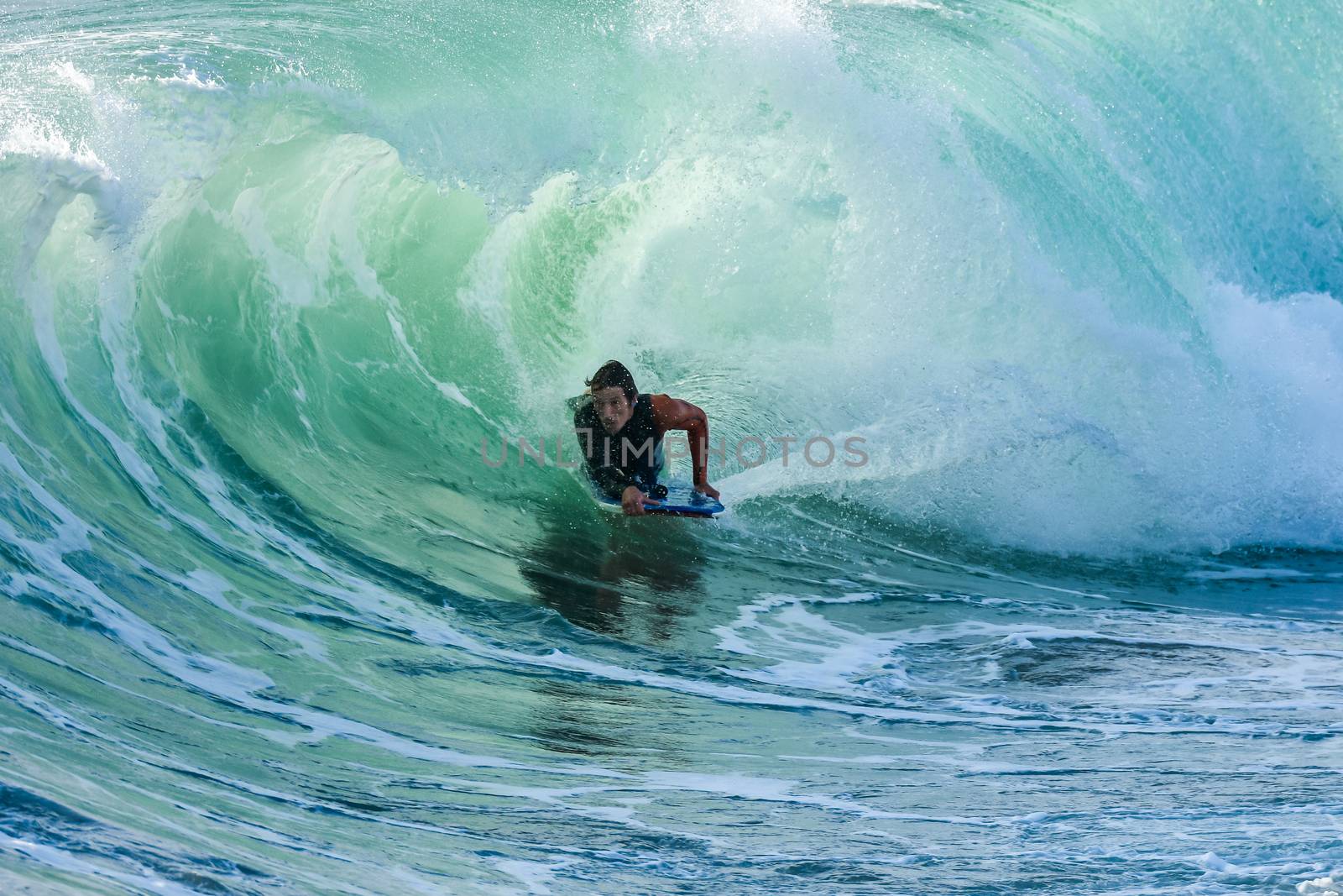 Bodyboarder in action on the ocean waves on a sunny day.