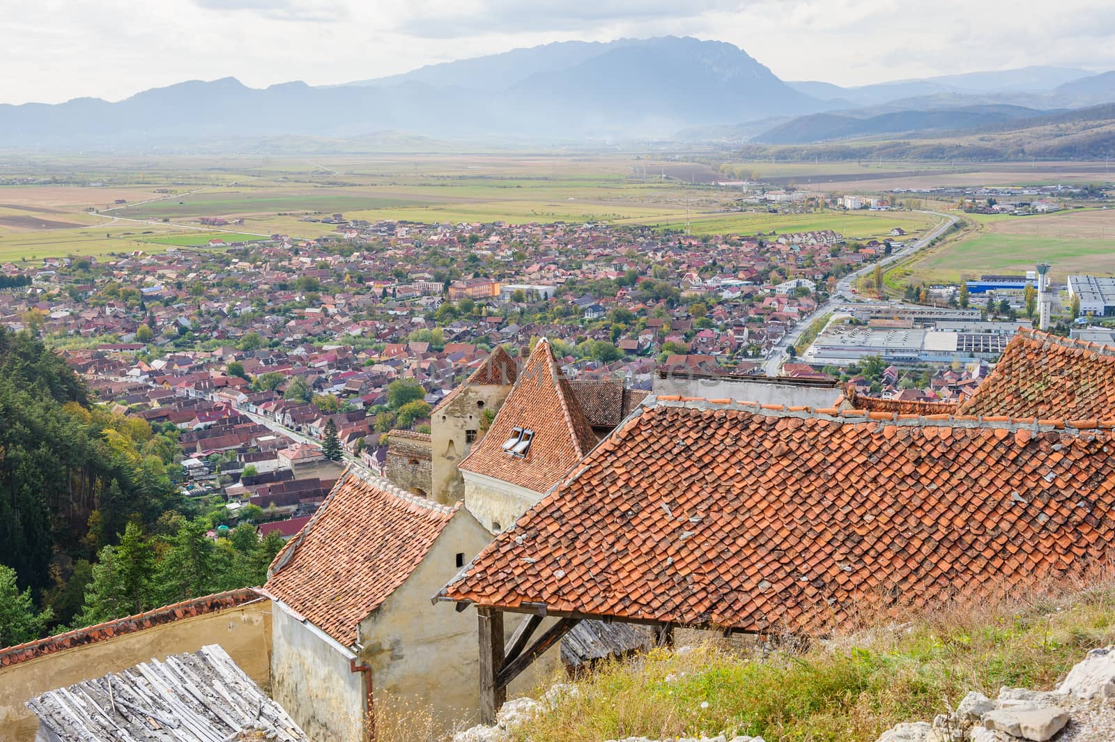 Rasnov, Brasov, Transylvania, Romania - 21th October 2014: View to the modenr town over the roofs of of Medieval saxon fortress Rosenau