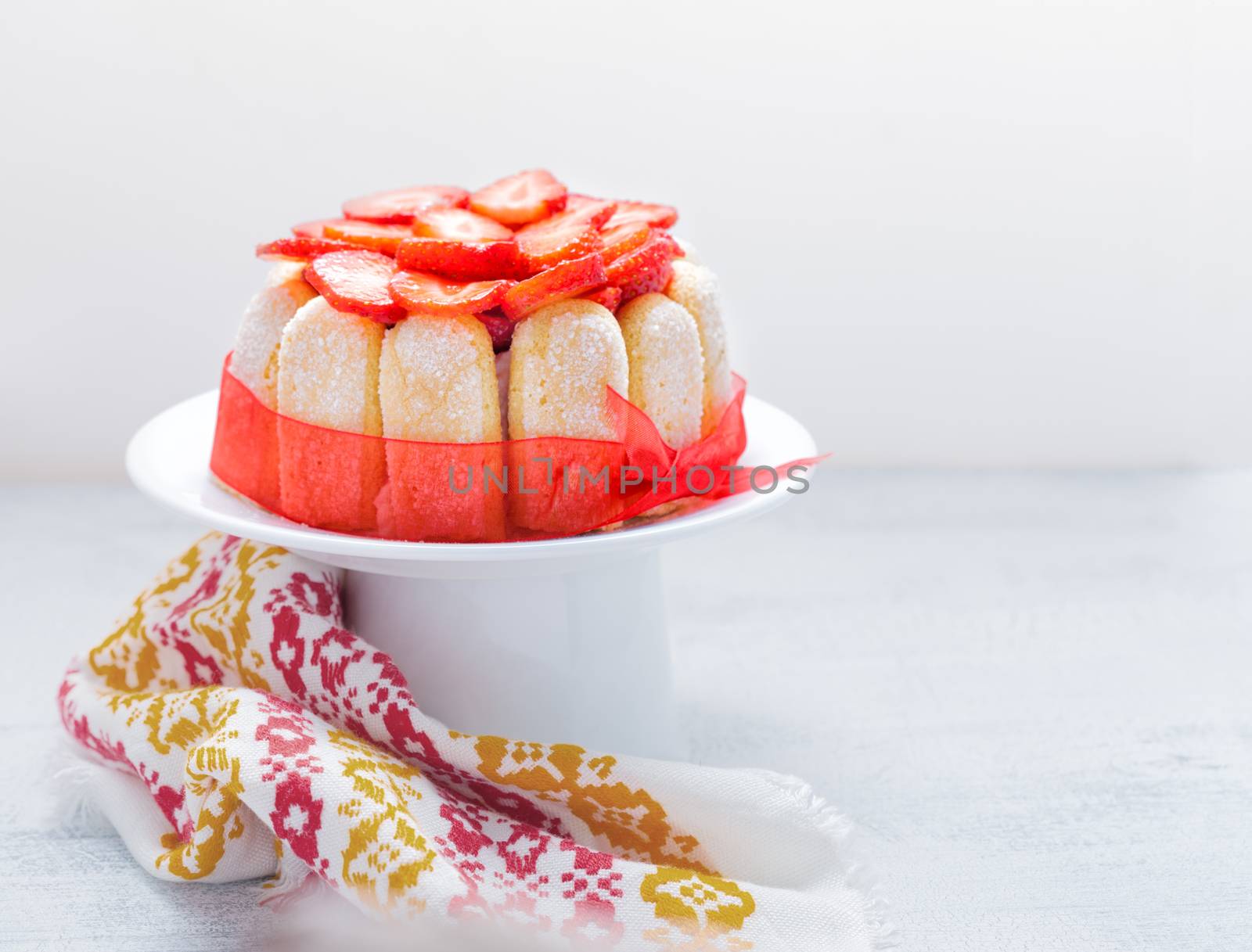 Yogurt strawberry cake with savoiardi biscuits on a plate