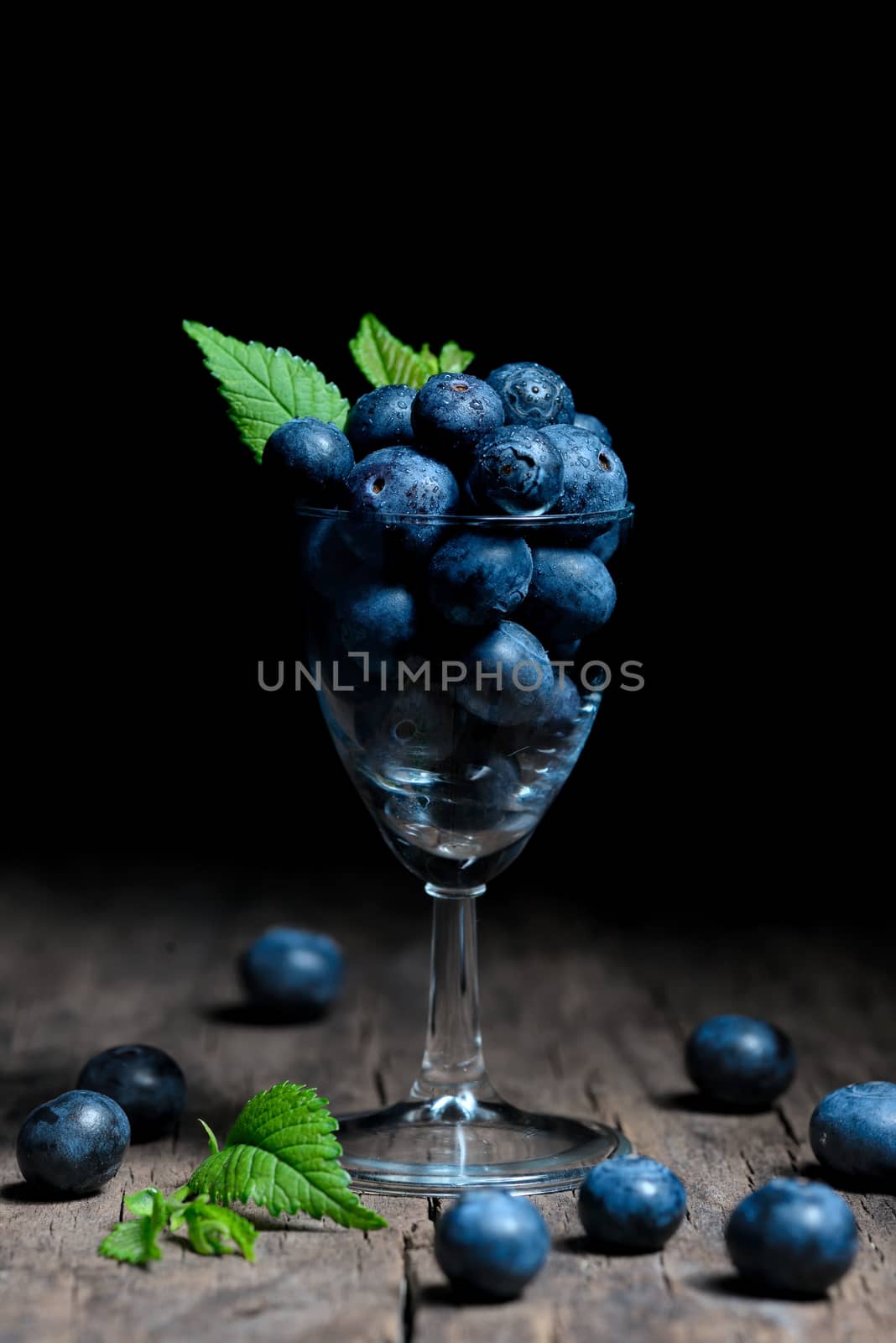 Blueberries with leaves in small glass