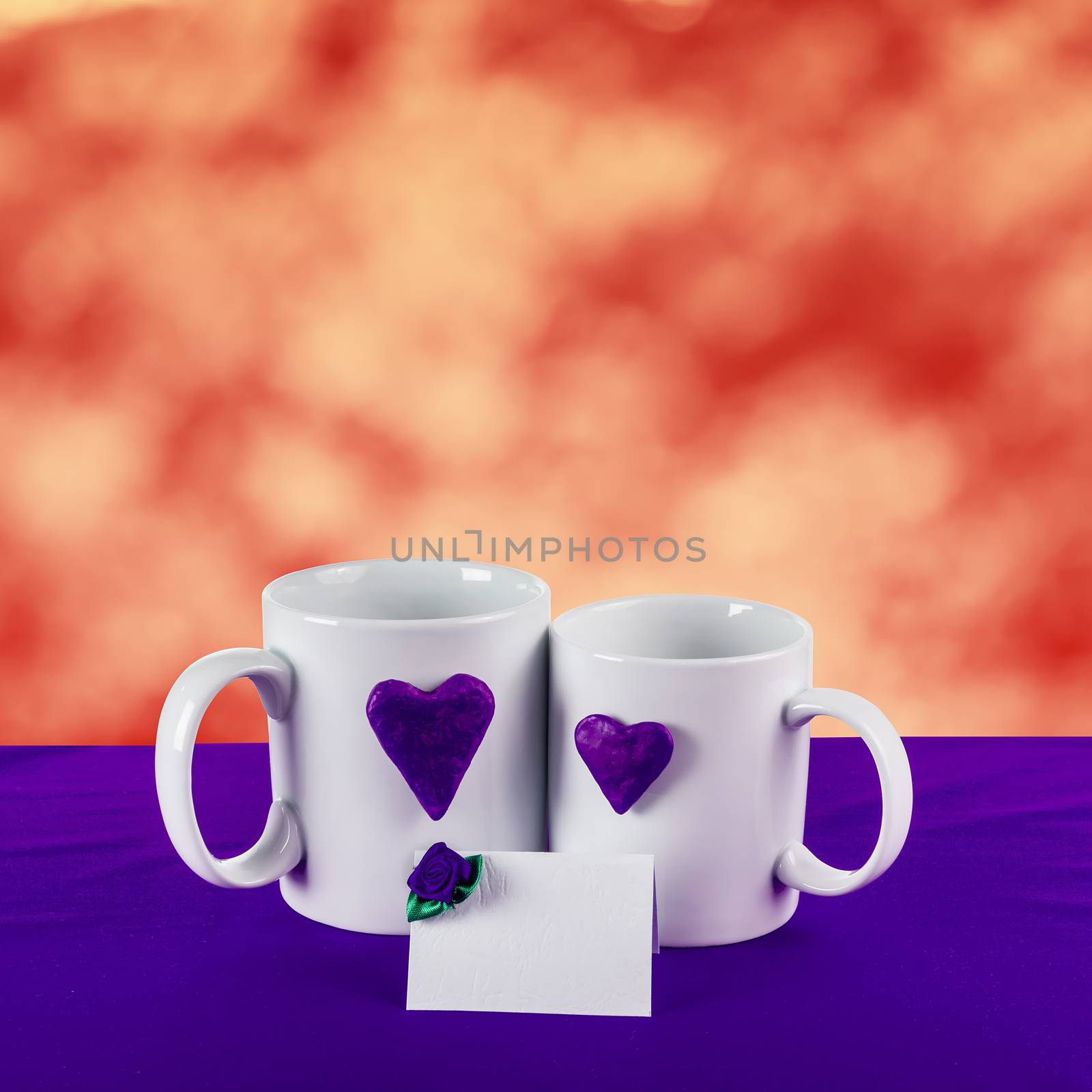 love card with red blur background. blue heart on a white tea cup on a blue fabric