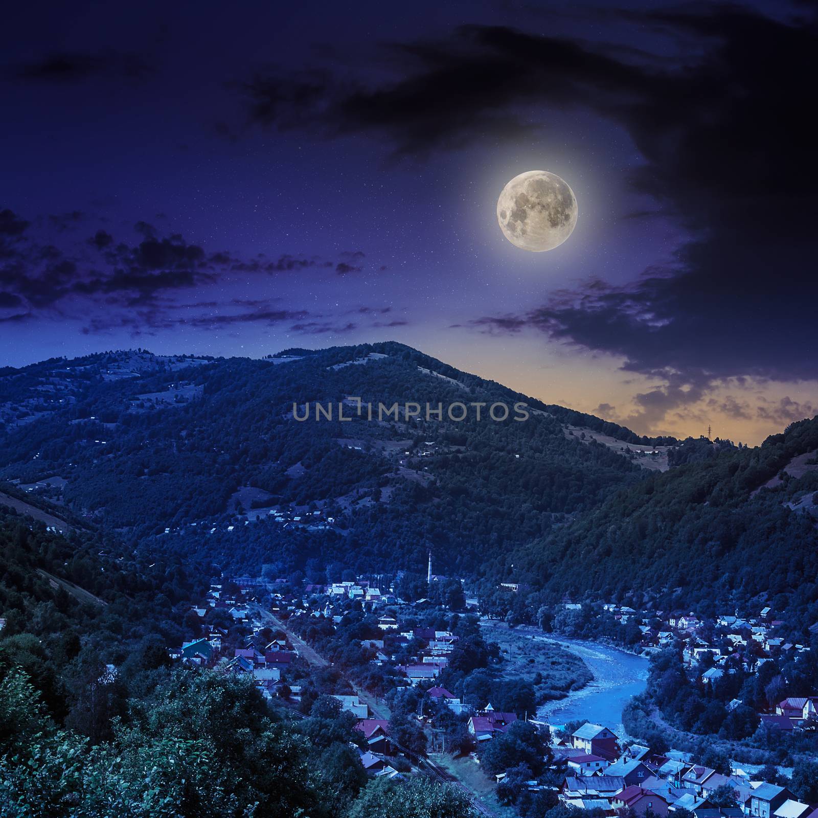 autumn landscape. village by the river. light fall on forest on mountains in moon light