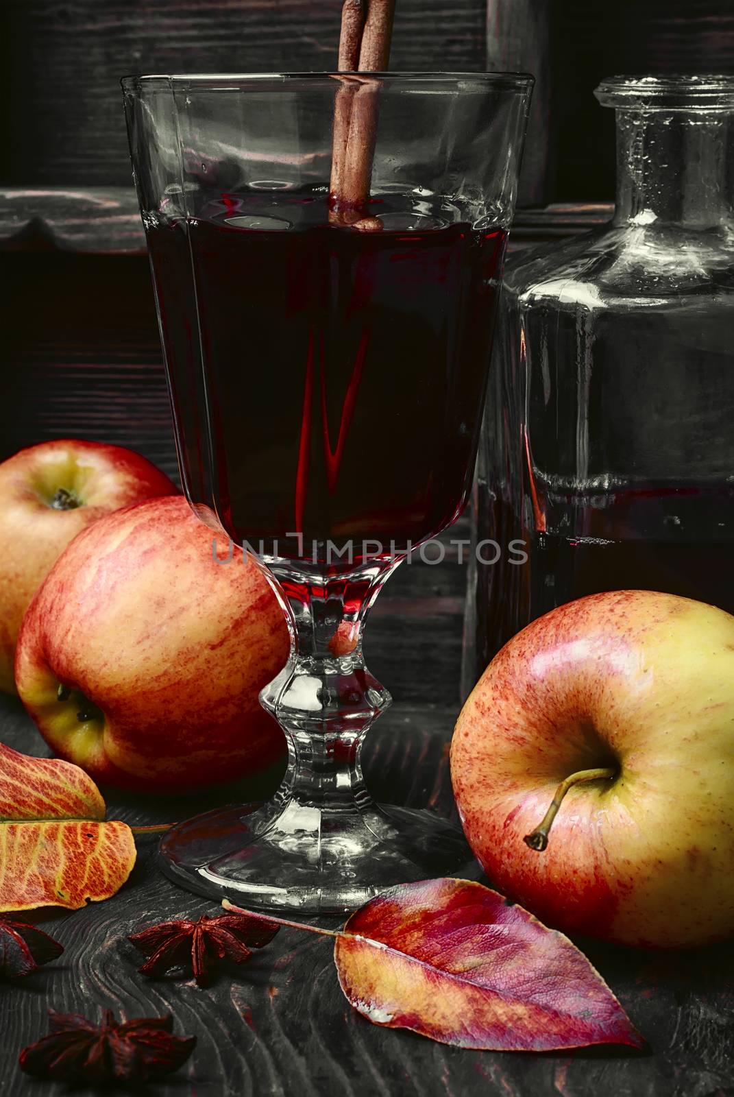 Warming autumn cocktail sangria with apple in glass wine glass.Dark key