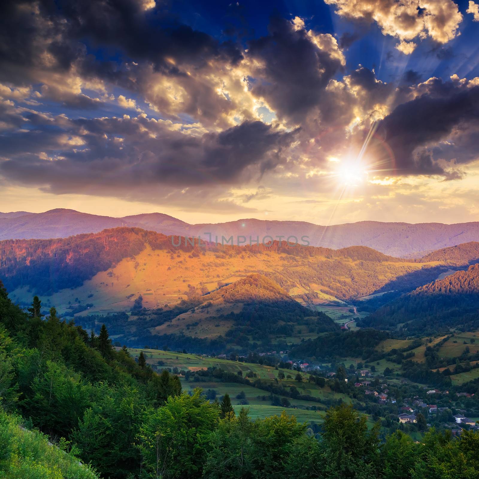 autumn landscape. village on the hillside. forest on the mountain light fall on clearing on mountains at sunset light