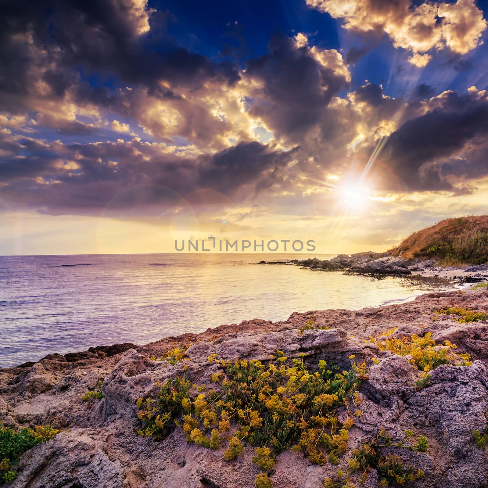 sea ​​wave attacks the boulders and is broken about them at sunset in evening light