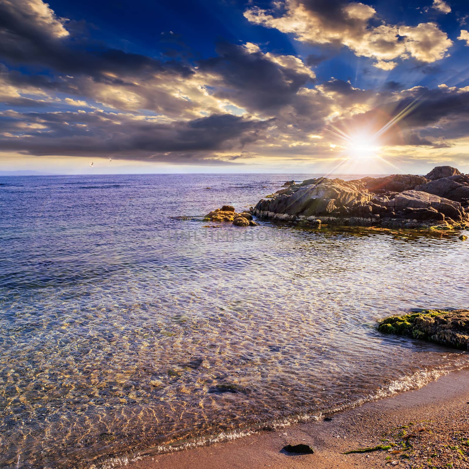 sea waves breaking on the sandy beach at sunset by Pellinni