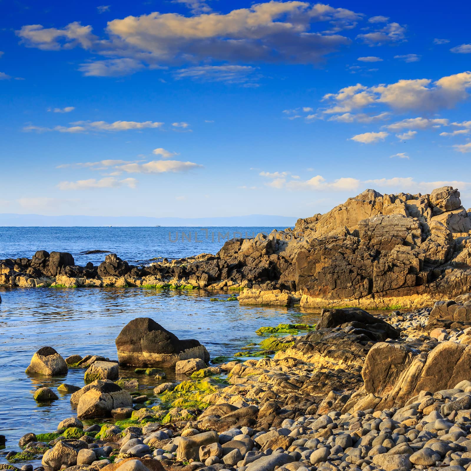 sea wave attacks the boulders and is broken about them