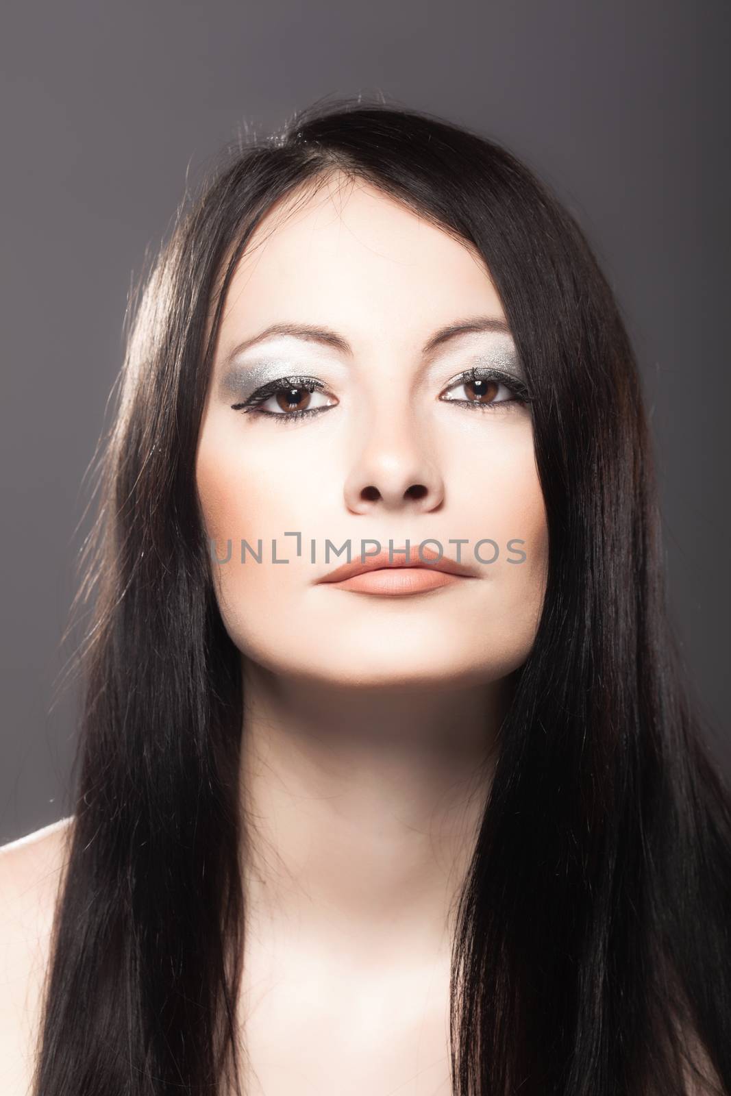 studio portrait of a beautiful brunette girl looking at camera