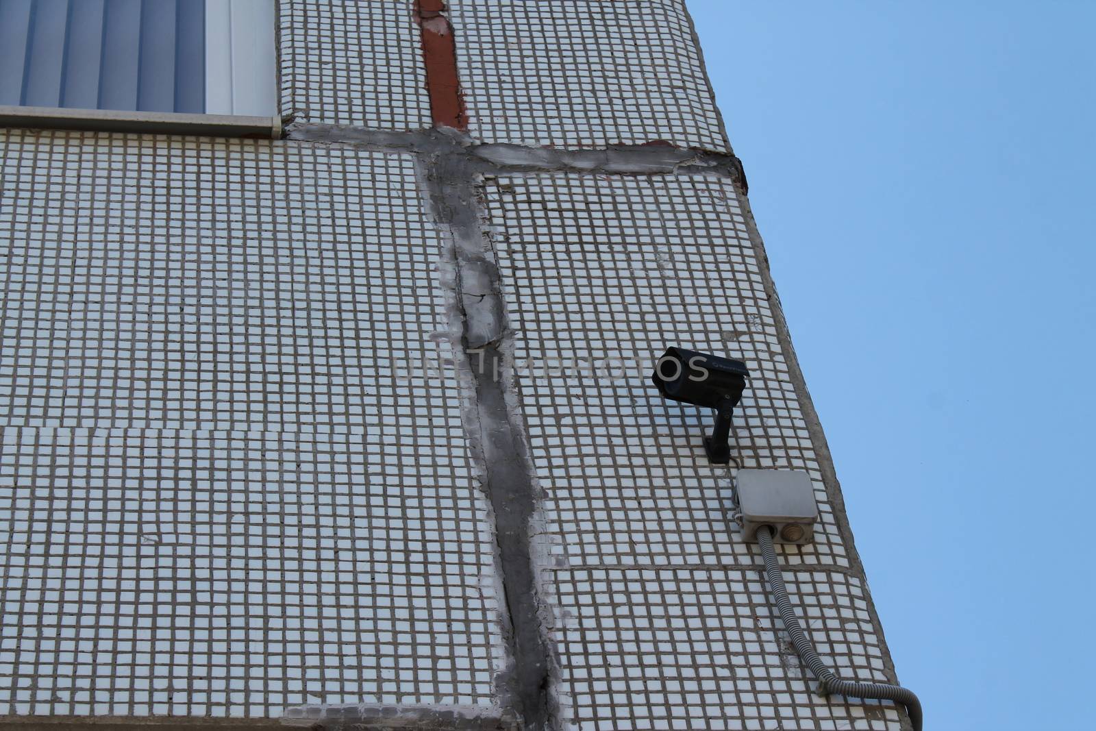 CCTV camera hanging over the entrance of a house.