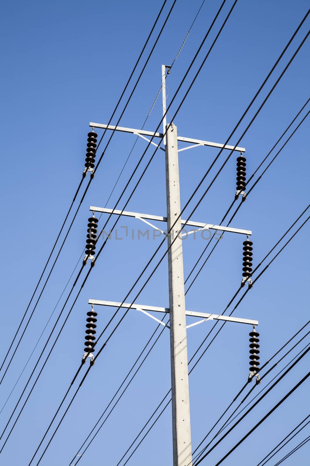 Power pole on stand. Electrical wires on a pole on blue sky background. Electric supply of big city. Land communications.