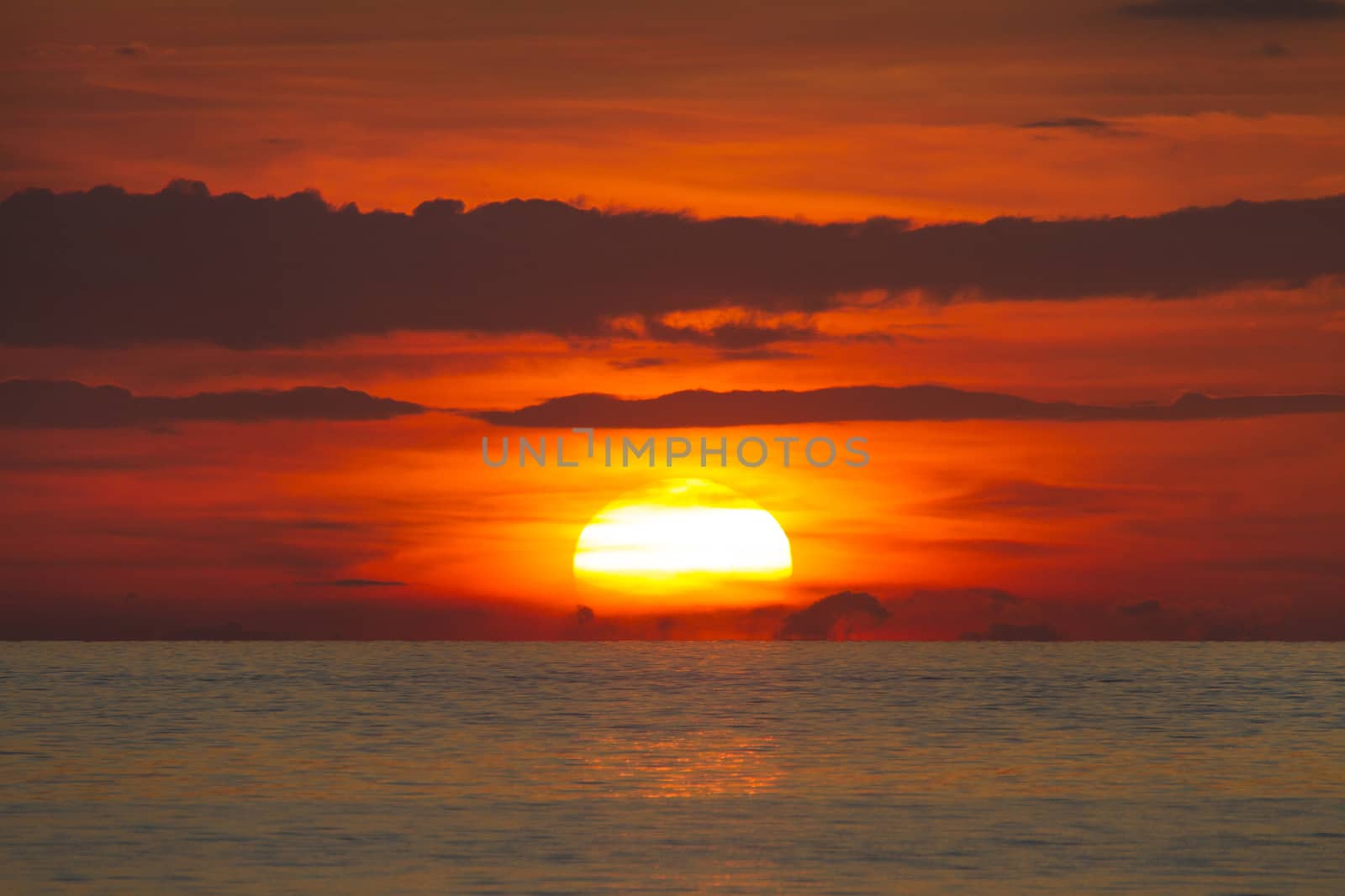 Evening at sea,Coast of the sea at colorful sunset , Thailand. Beach sunset is a golden sunset sky with a wave rolling to shore as the sun sets over the ocean horizon